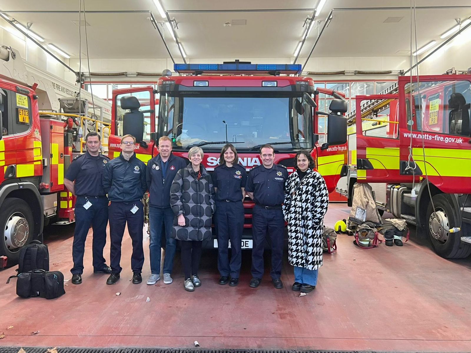 Nadia Whittome and Lilian Greenwood with Fire Brigades Union members in front of a fire engine.